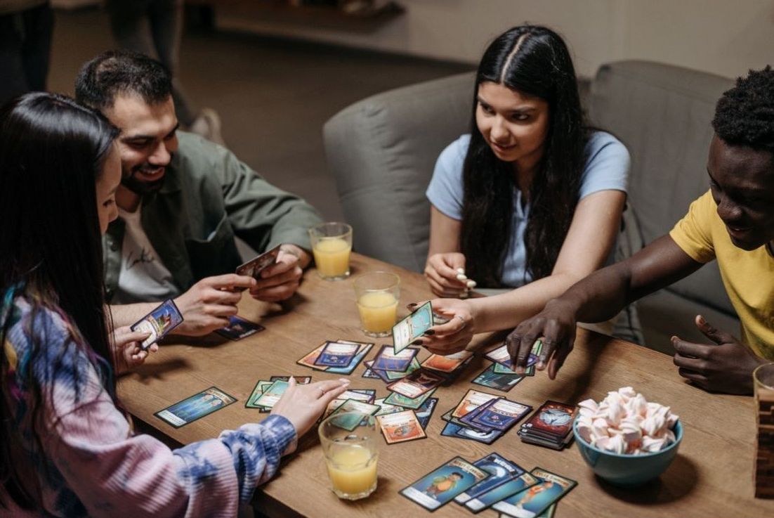 Friends playing a card game over drinks in the lounge
